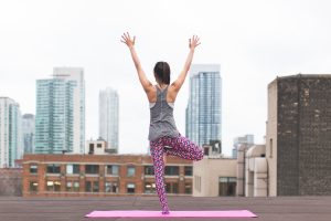 Woman Doing Yoga on Top of Building